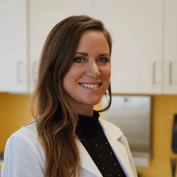 The Charm medical reviewer in a white coat, smiling in the clinic